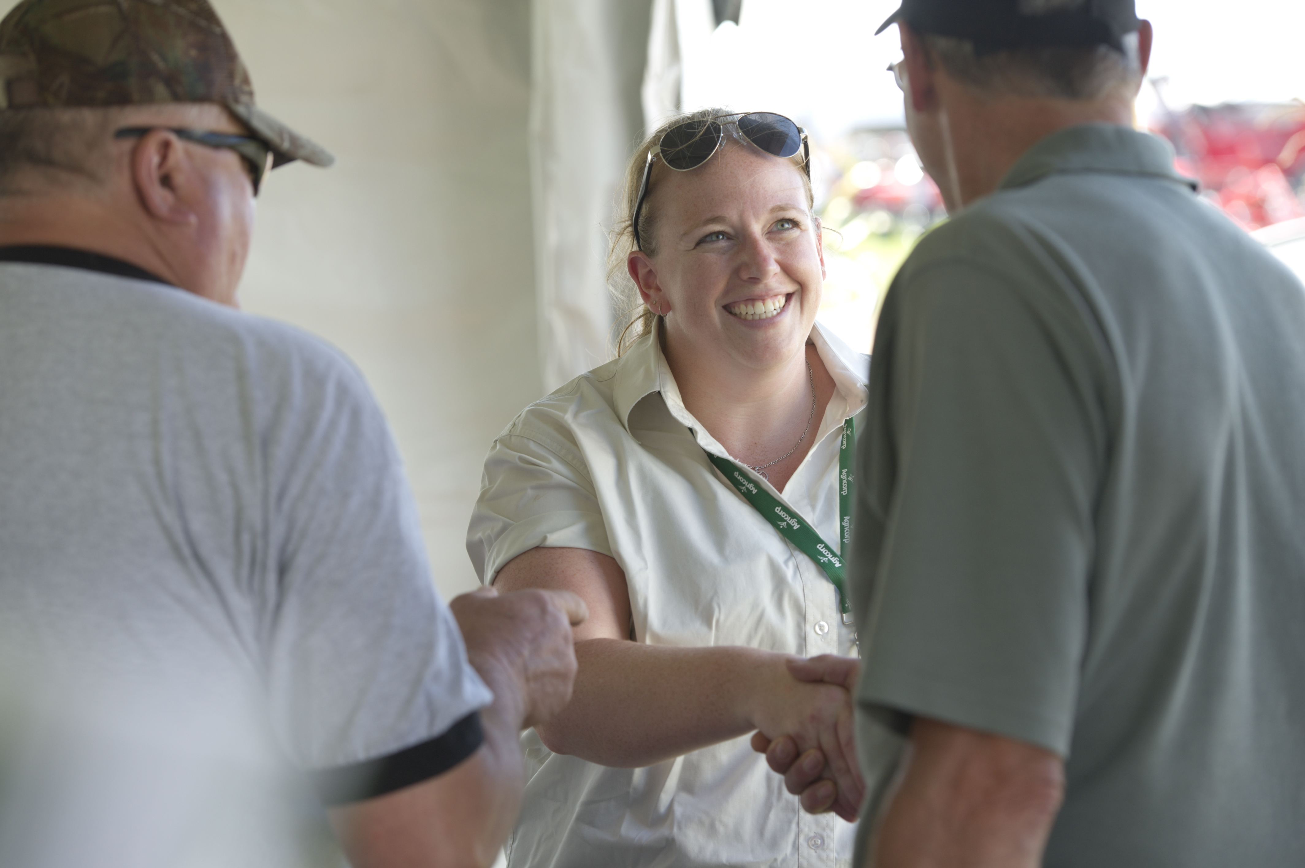 An Agricorp staff member shakes hands with a producer at a farm show.