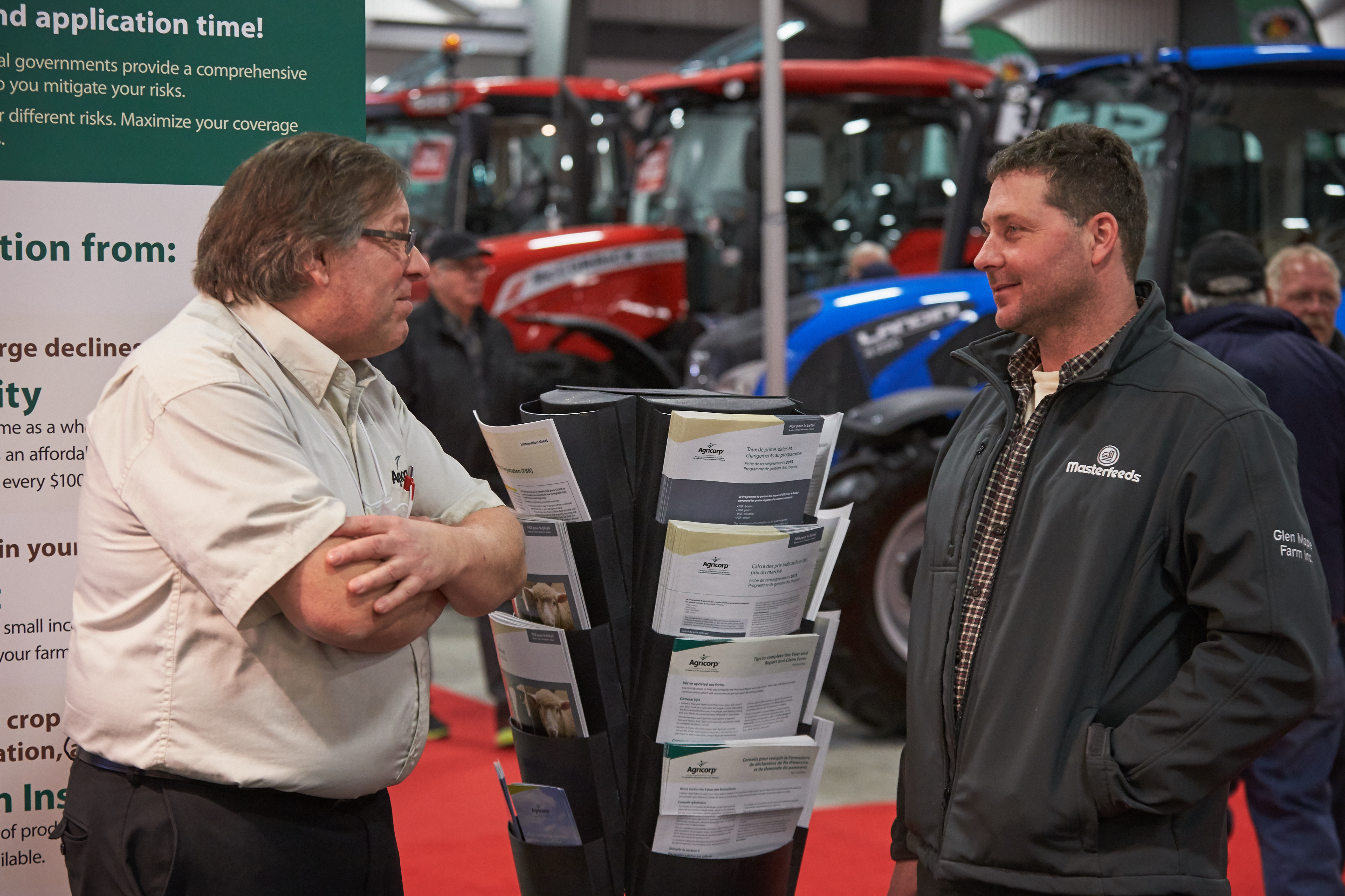 An Agricorp staff member talks with a producer at a farm show.
