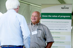 Un employé d’Agricorp s’entretient avec un producteur lors d’une exposition agricole.