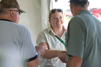 Agricorp staff members talk with producers at a farm show.